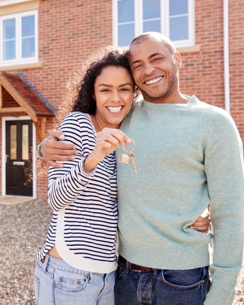 Married couple outside their first home
